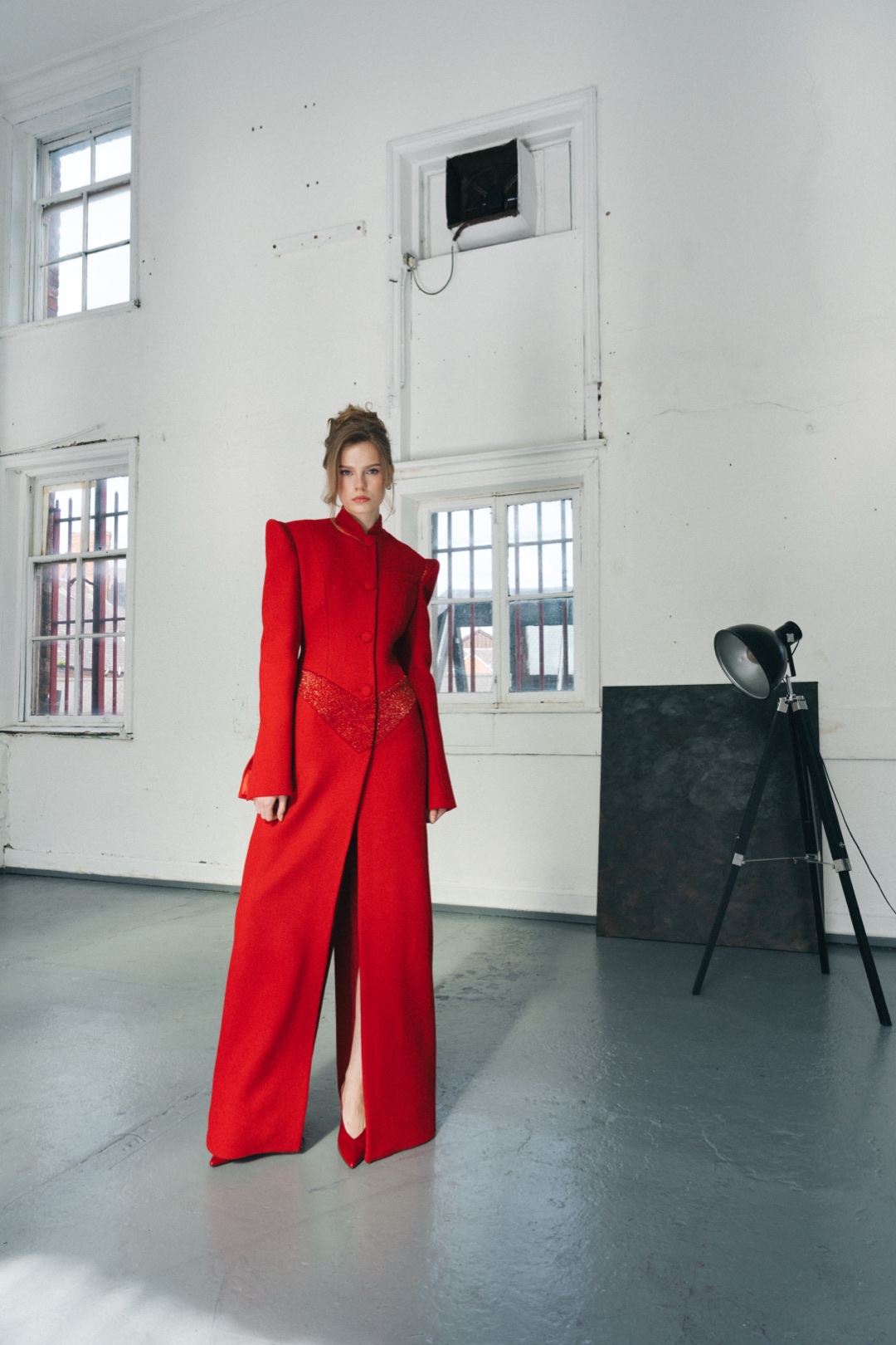 The red coat, full length from the front in a white studio