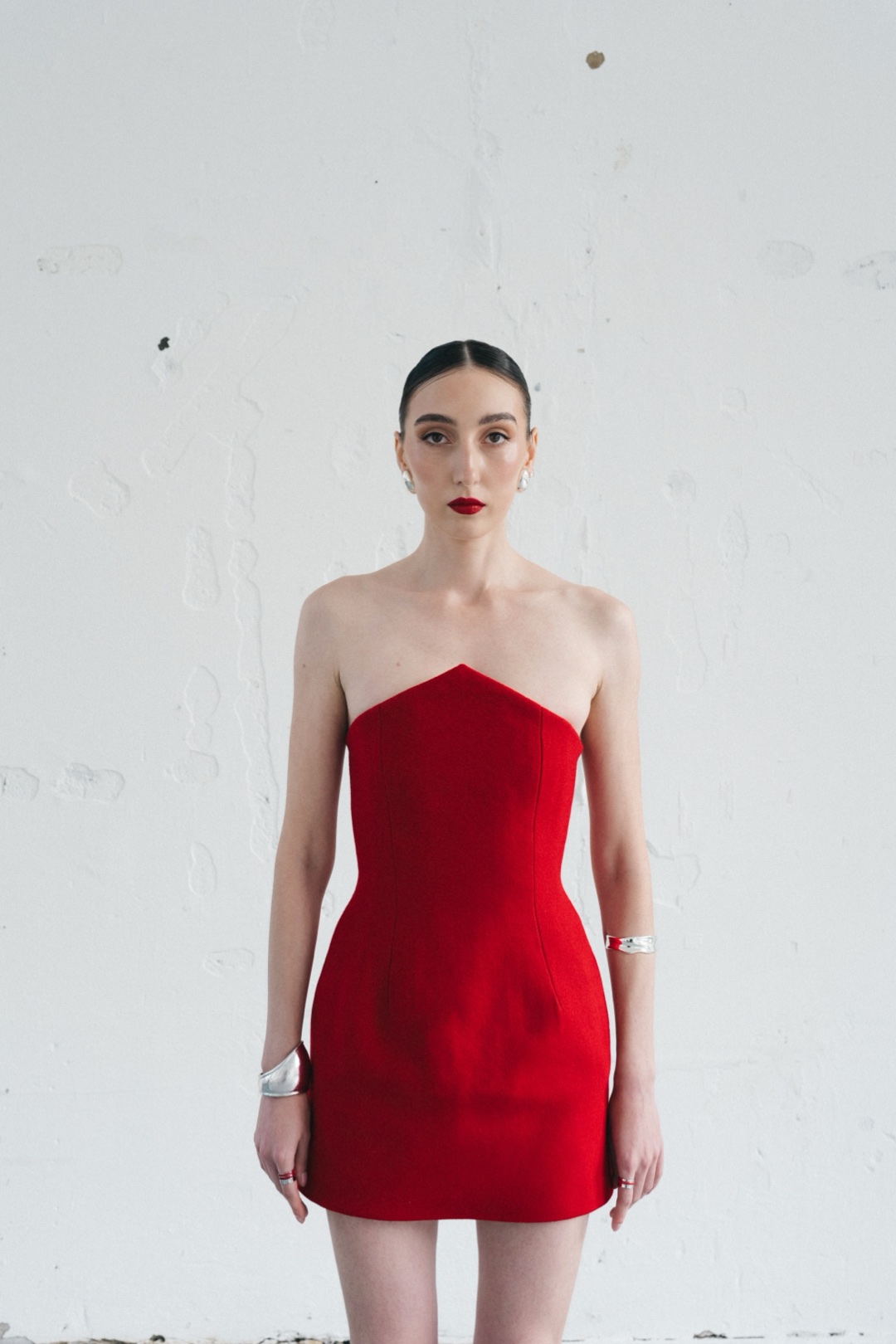 The red mini, front view showing the pointed neckline and shaped seams