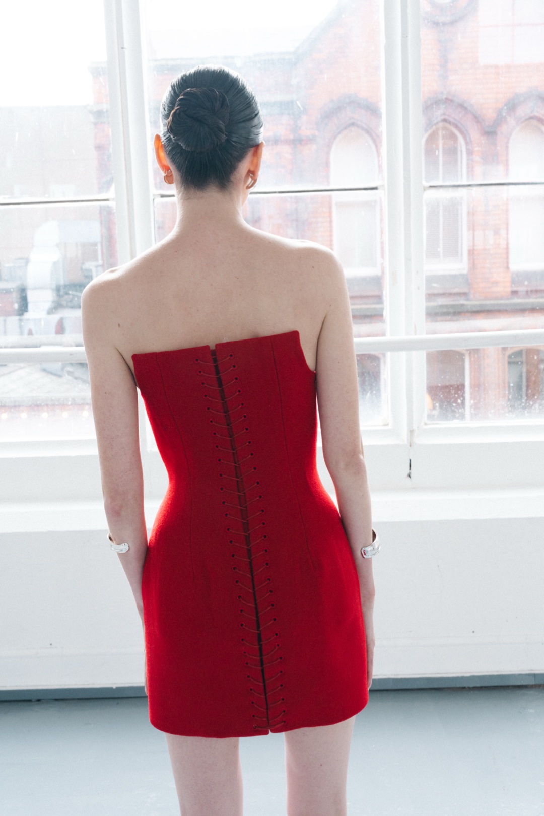 The red mini, back view by the window, laced from top to hem