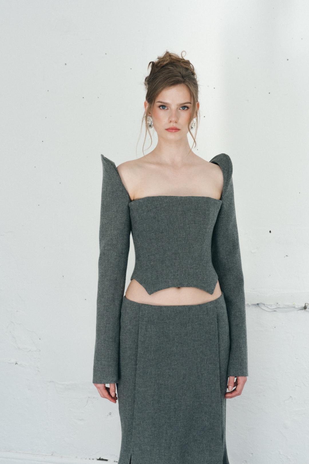 The grey bustier, front view, the square neck and sculptural shoulder
