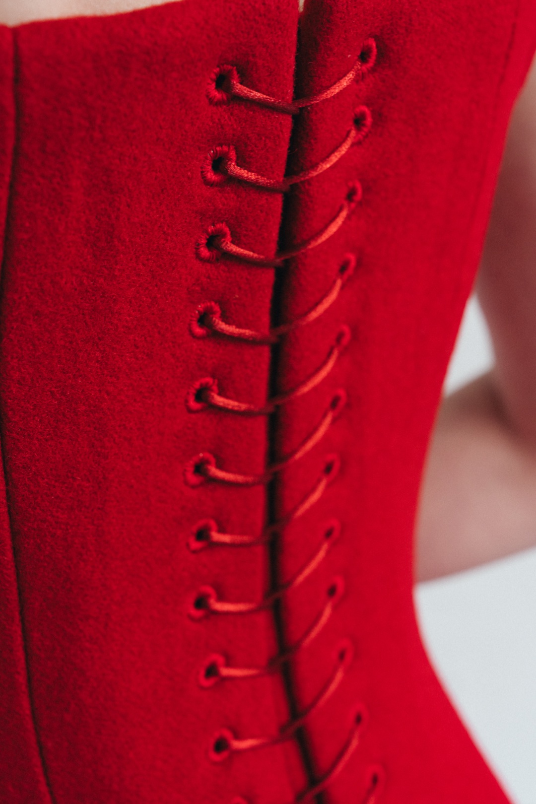 The red mini, close-up of hand-worked eyelets and red lacing