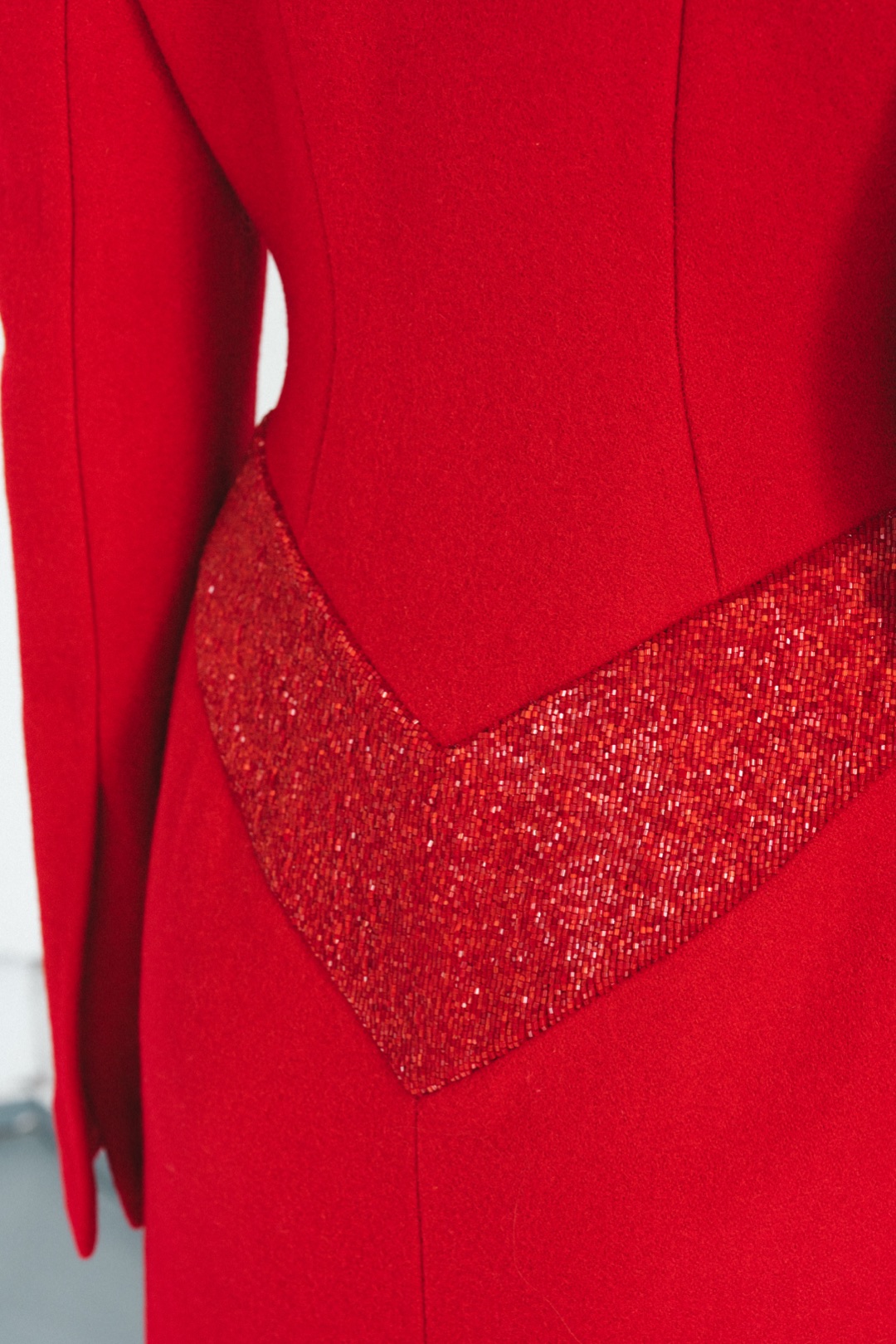 The red coat, close-up of hand-sewn beads in the chevron at the back