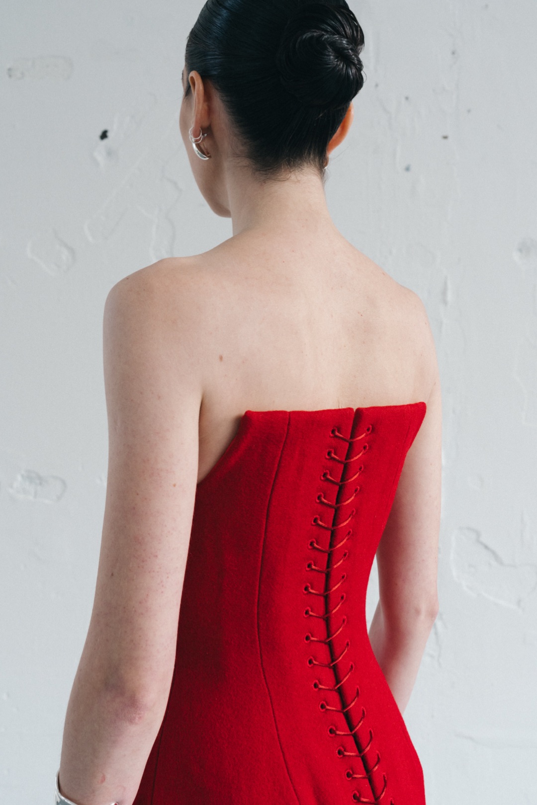 The red mini, upper back laced through eyelets worked one by one
