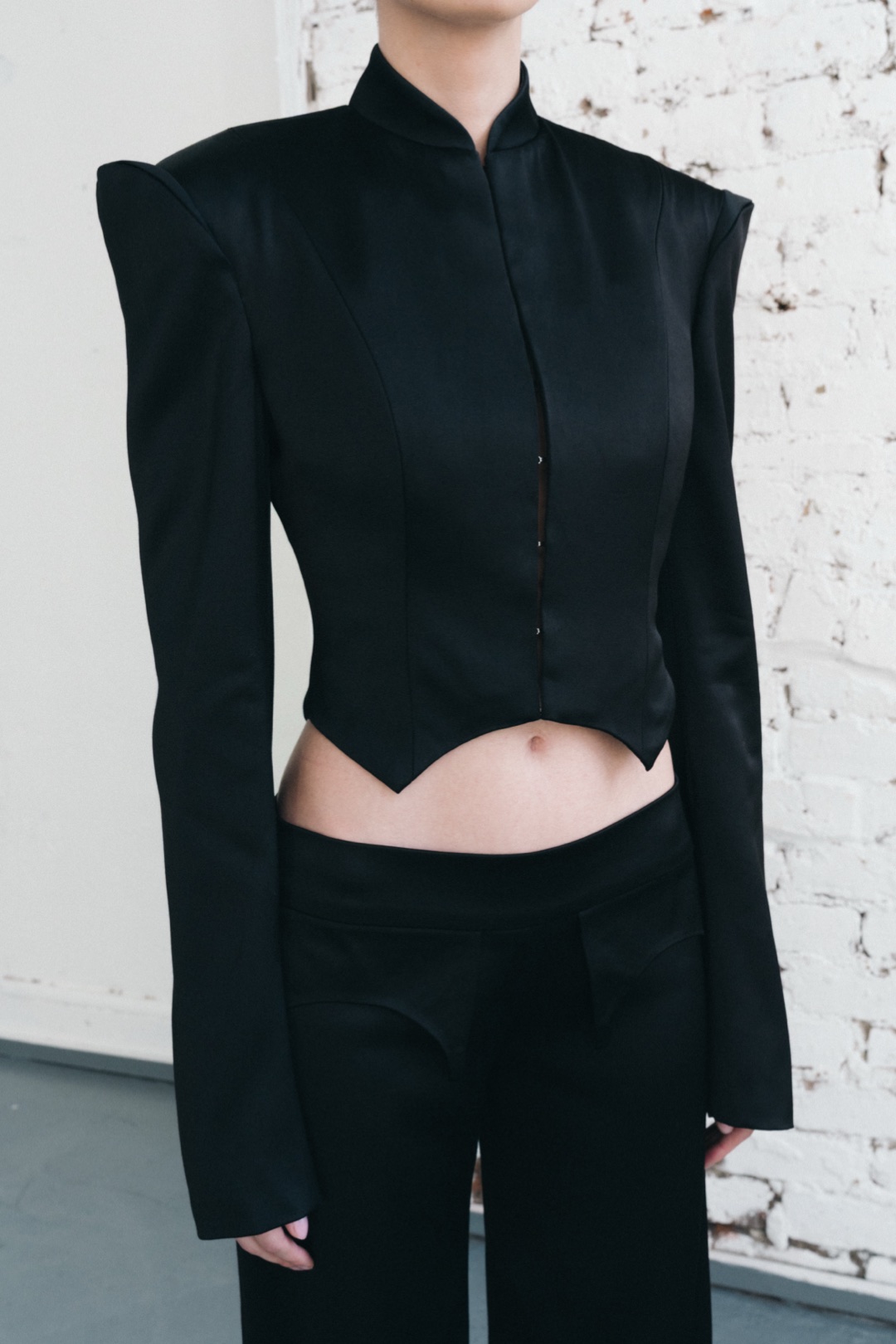 The black suit, close-up of the pointed hem above the trouser pockets