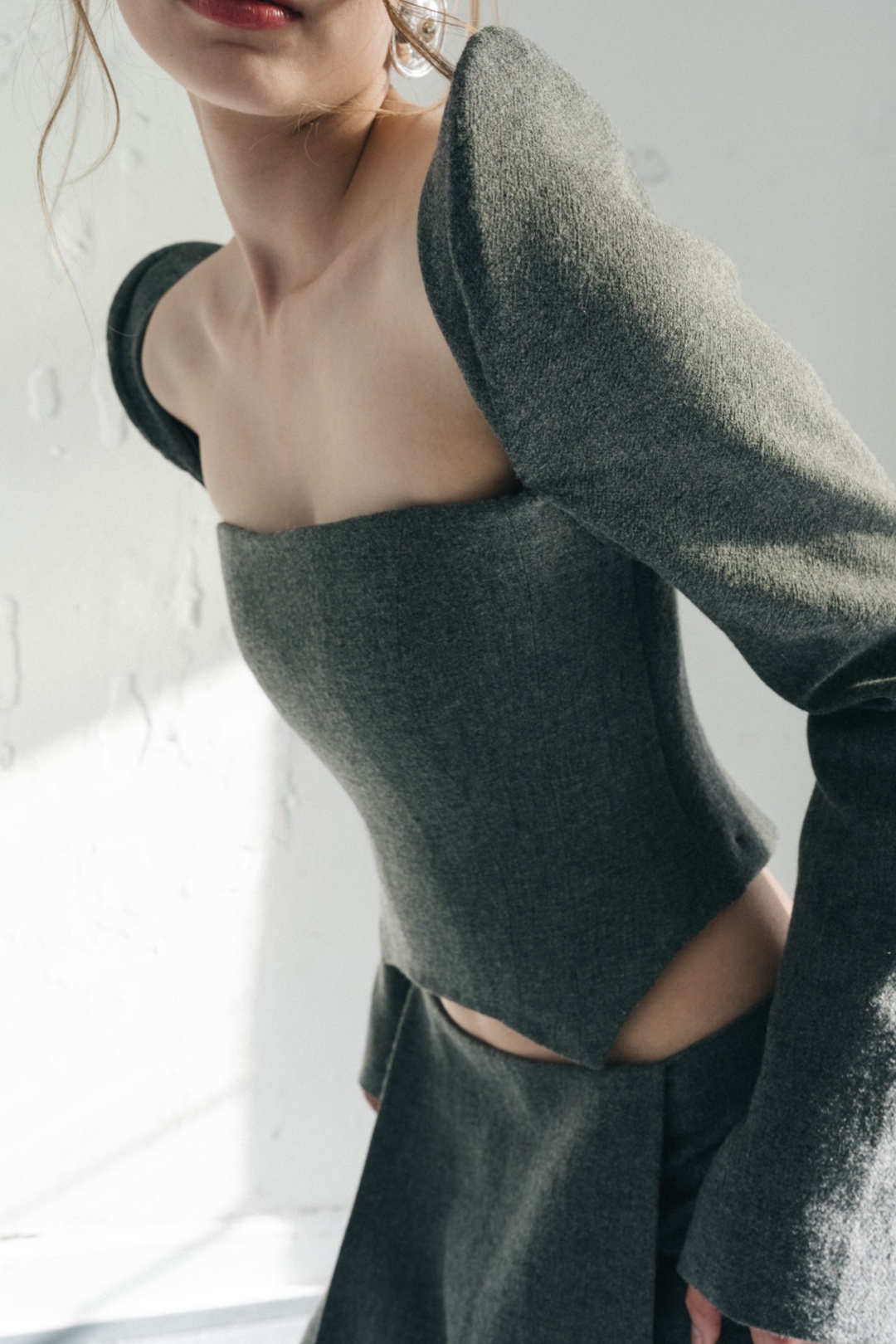 The grey bustier, close-up in sunlight, the linen weave across shoulder and bustier