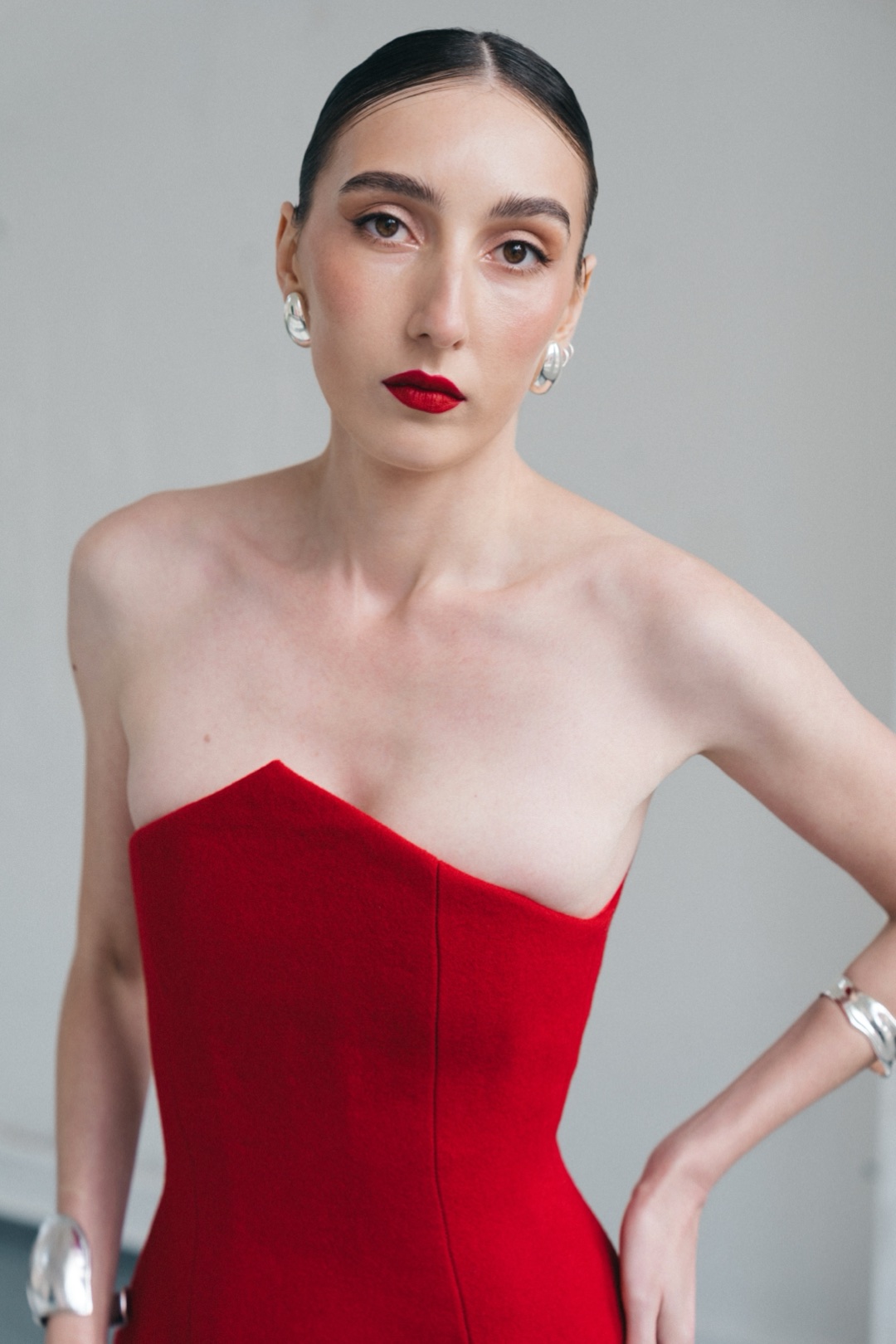 The red mini, waist-up view with one hand on the hip