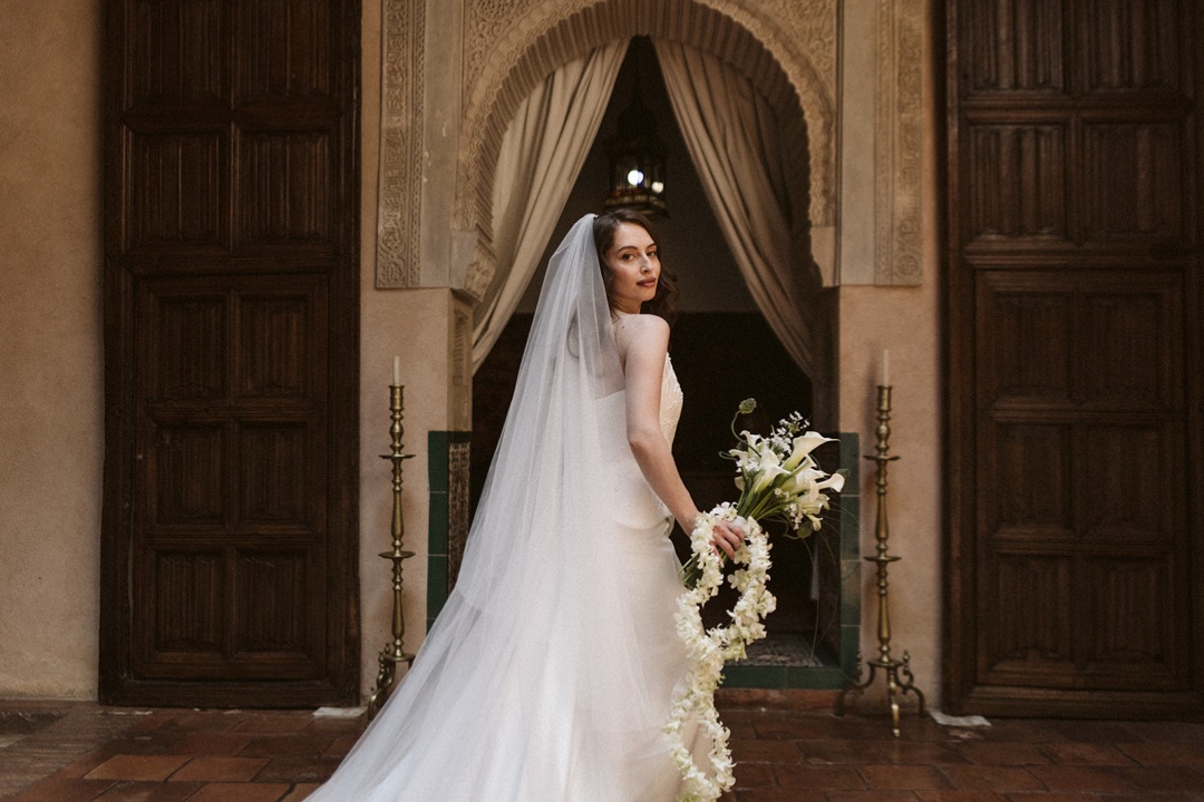 A bride in a long veil in a Moorish courtyard in Granada