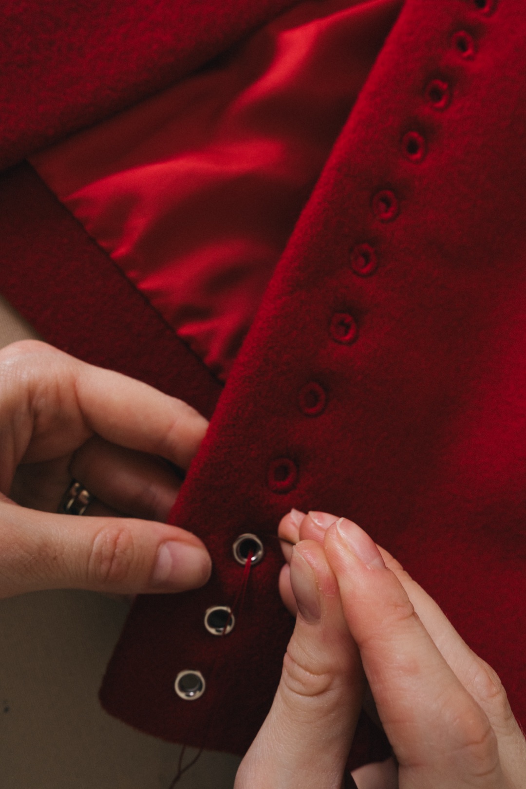 Working eyelets by hand in red wool