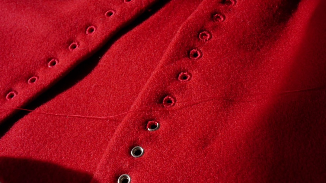 Eyelets worked by hand in red wool